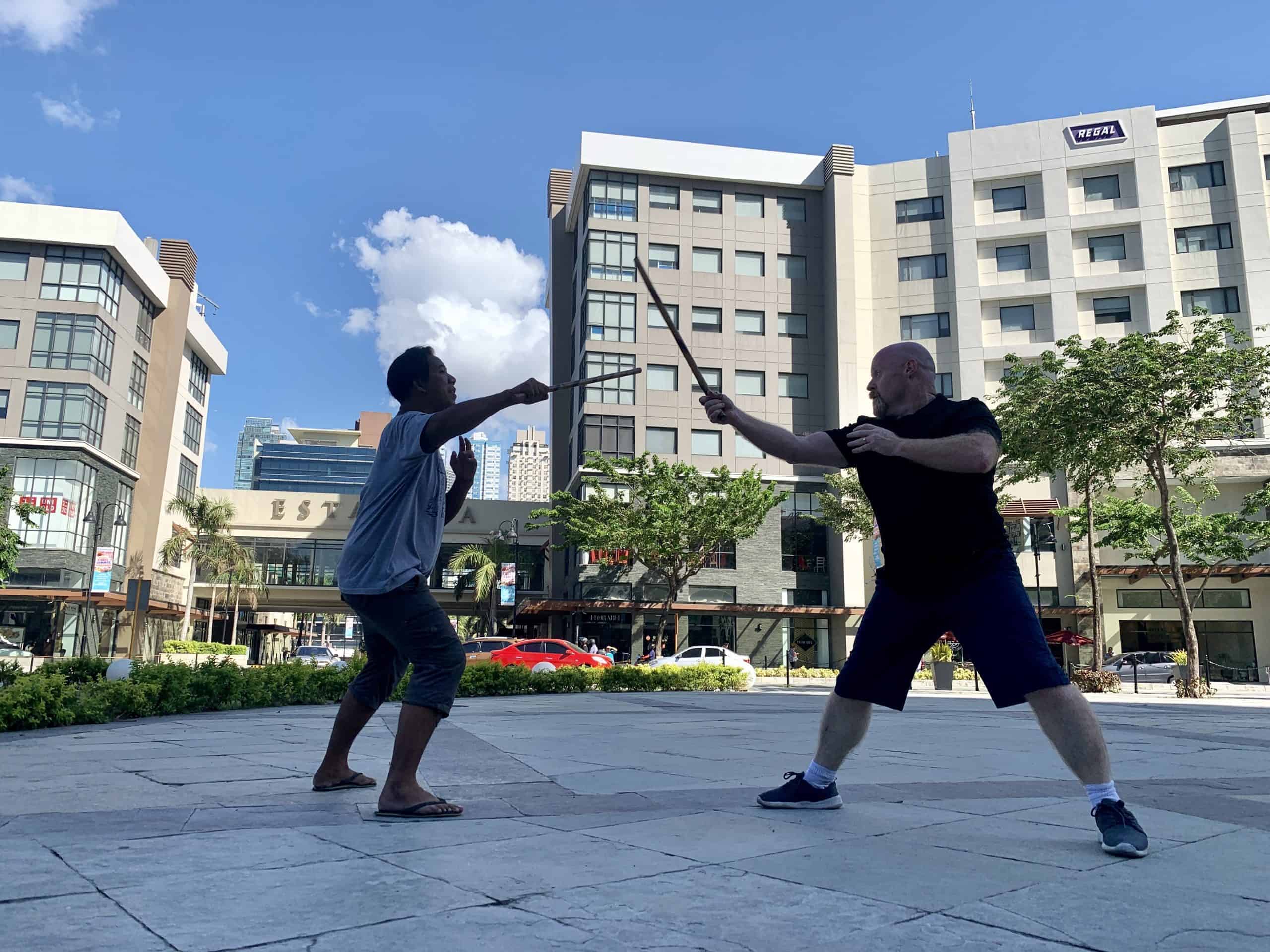 Large group of students practice filipino eskrima arnis stick